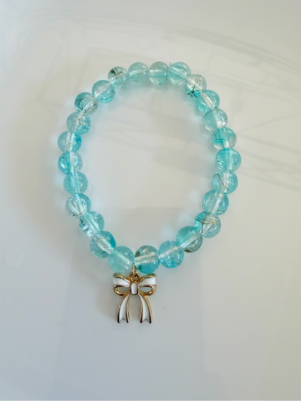 Aqua Beaded Stretch Bracelet with Gold Bow Charm